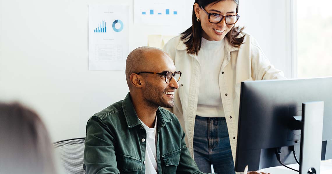 Happy man and woman in front of computer