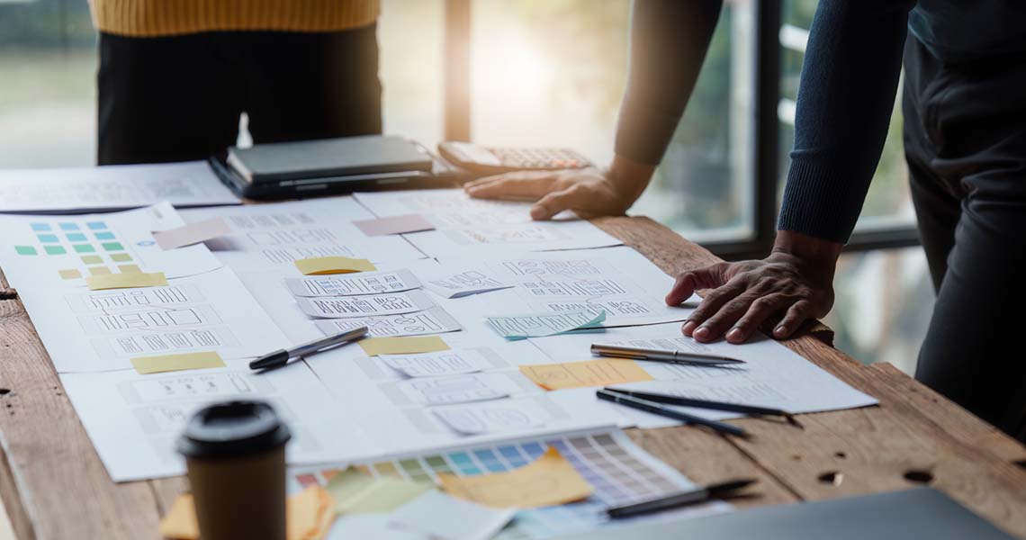 Står framför ett skrivbord med en KANBAN-bräda