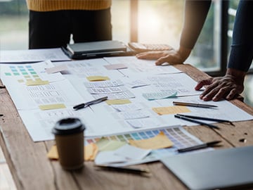 Står framför ett skrivbord med en KANBAN-bräda